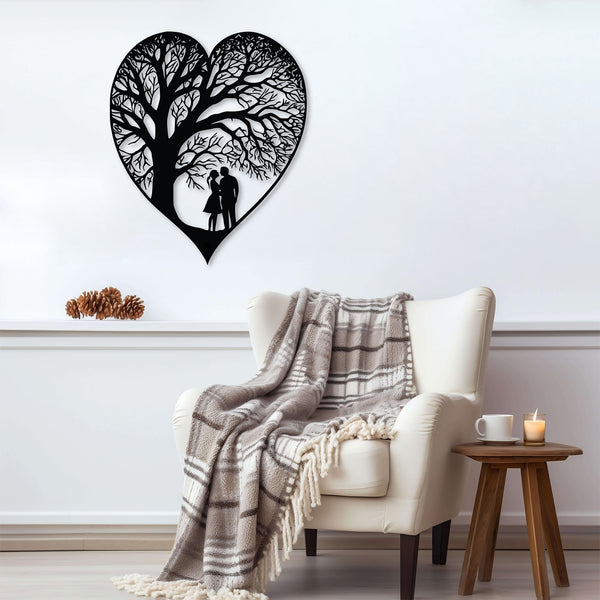 A metal heart-shaped wall decor with a tree-like pattern and a silhouette of a couple underneath. This symbolizes joy, and the growth of love. This piece of art is hanging on a wall above a cozy chair with a plaid blanket.