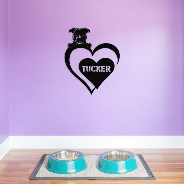 Personalized metal sign featuring a pit bull and a heart-shaped name plaque, displayed on a purple wall above dog bowls.