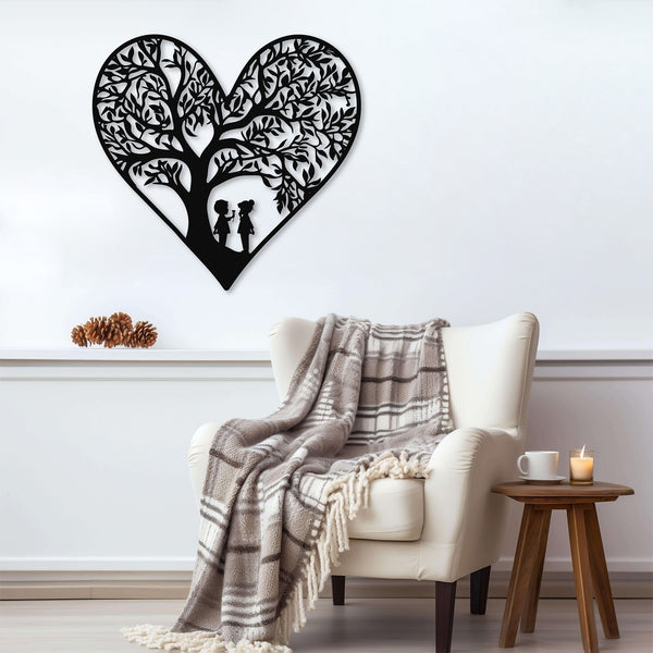 Black metal heart wall art featuring two children playing beneath a tree, displayed above an armchair with a plaid blanket.