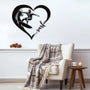 Black metal wall art featuring a surfer riding a wave inside a heart shape with the word 'surf' written in cursive. The art is displayed on a light gray wall above a cozy armchair with a plaid blanket draped over it.