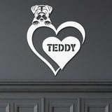 White metal sign with a dog silhouette peeking over a heart, with the name 