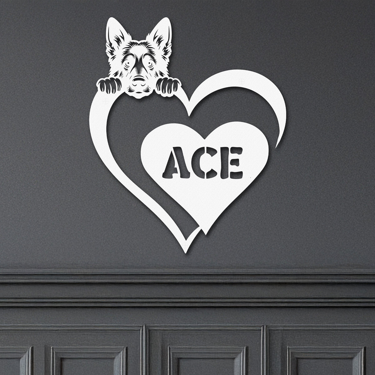 White metal sign with a German Shepard dog silhouette peeking over a heart, with the name "Ace" written inside the heart, mounted on a gray wall.