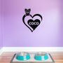 Personalized metal sign featuring a yorkshire terrier and a heart-shaped name plaque, displayed on a purple wall above dog bowls.