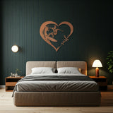 Copper metal wall art featuring a surfer riding a wave inside a heart shape with the word 'surf' written in cursive. The art is hung on a dark wall above a bed with white and gray bedding in a modern bedroom setting.