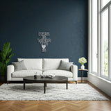 Silver metal sign with the phrase 'Home Is Where The Heart Is' displayed above a white sofa in a living room with large windows.