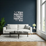 Silver wall decor with a cutout butterfly and the quote 