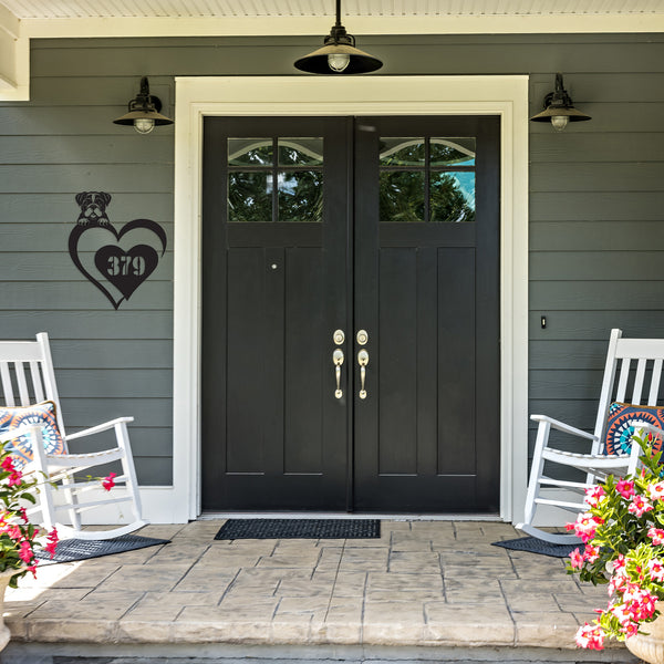 Decorative house number sign featuring a dog silhouette and the number 379, hanging on a gray house wall.