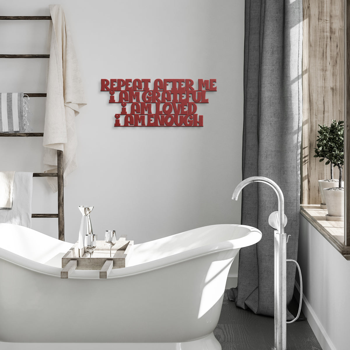 Red metal inspirational sign hanging next to a white bath tub, the sign says " Repeat after me, I am grateful, I am loved, I am enough". 