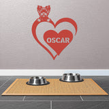 Red metal sign featuring a yorkie and a heart-shaped name plaque, displayed on a light-colored wall.