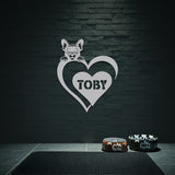 Silver metal sign with a dog silhouette peeking over a heart, with the name 
