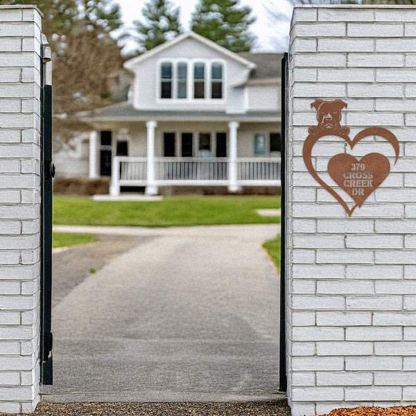 White brick enterance to a home,on the left side of the entry is a copper metal pit bull heart sign with " 379 Cross Creek Dr" on the sign. 